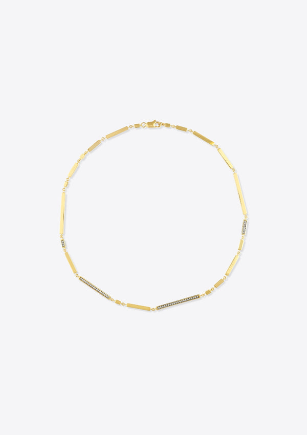 Necklace with gold bars and diamonds on a grey background