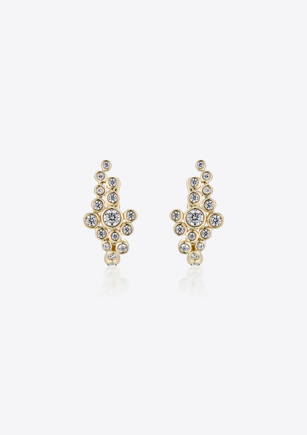 Gold earrings with small round asymmetric diamonds clustered together on a grey background