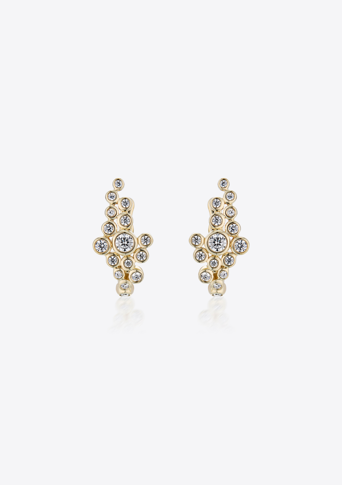 Gold earrings with small round asymmetric diamonds clustered together on a grey background