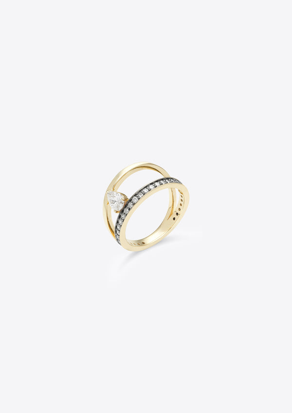 small diamond-set gold band with a plain gold band asymmetrically above, joined by a pear diamond. top down view, grey background