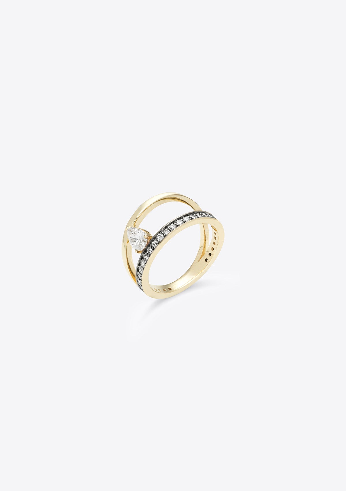 small diamond-set gold band with a plain gold band asymmetrically above, joined by a pear diamond. top down view, grey background
