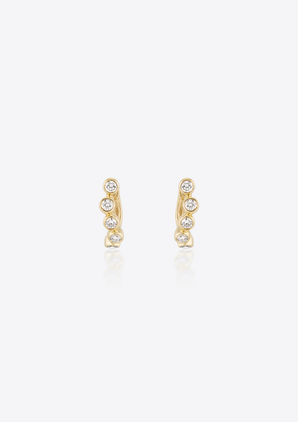 Gold earrings with small bezel-set diamonds shaped in a curve on a grey background. front view
