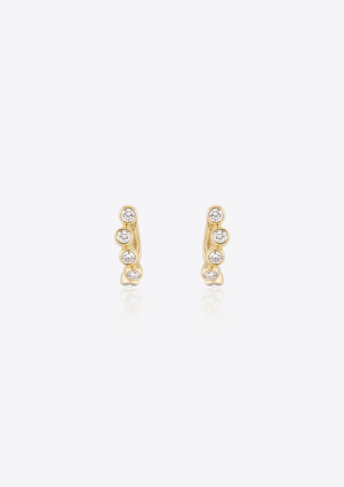 Gold earrings with small bezel-set diamonds shaped in a curve on a grey background. front view