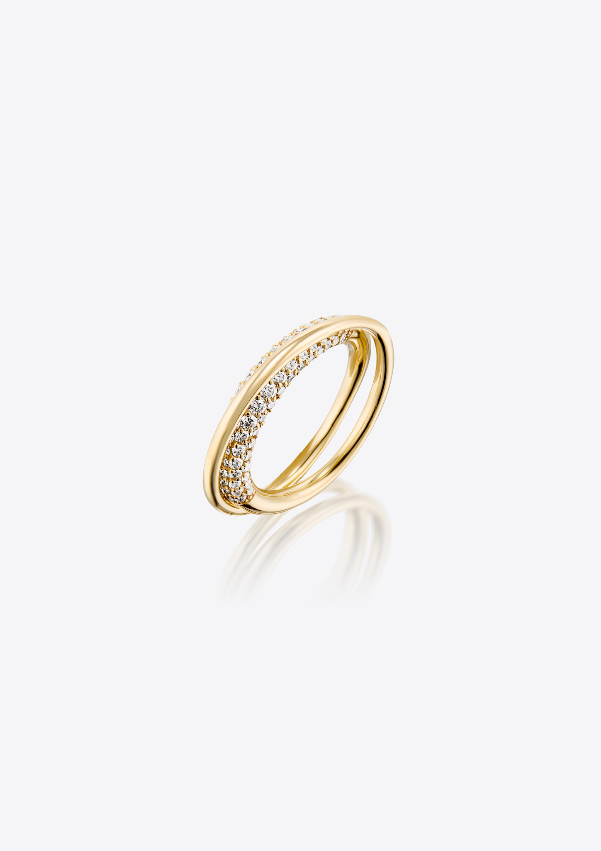 side view of gold sculptural infinity loop ring with pave diamonds on a grey background