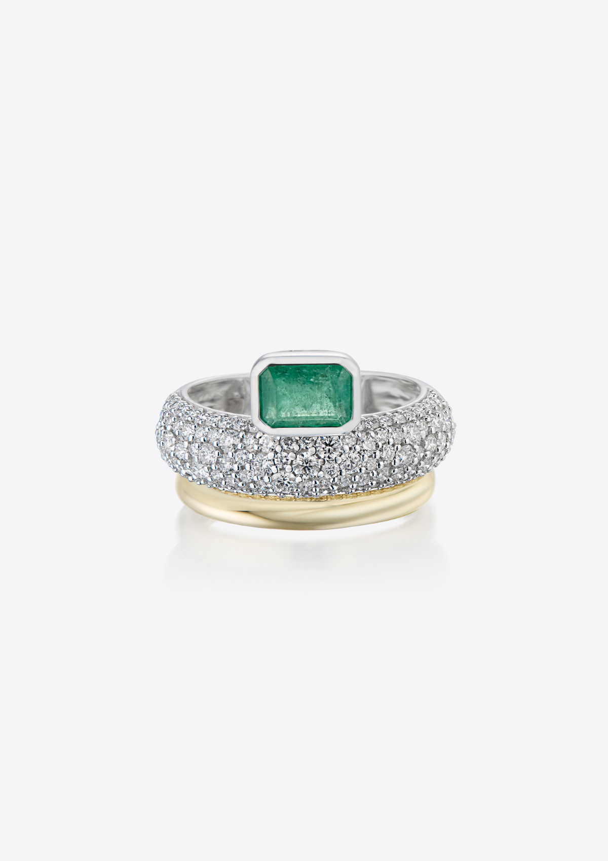 front view of white gold ring with pave diamonds and an emerald sitting on top. with a gold band underneath. on a grey background