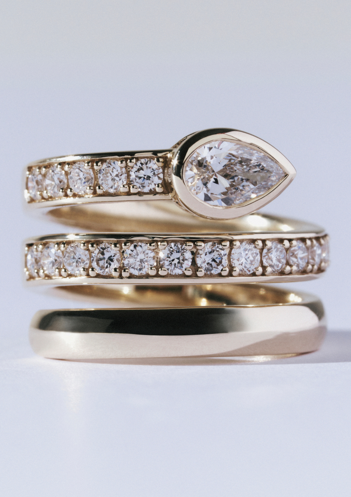 yellow gold spiral ring with small diamonds and one large pear-shaped diamond