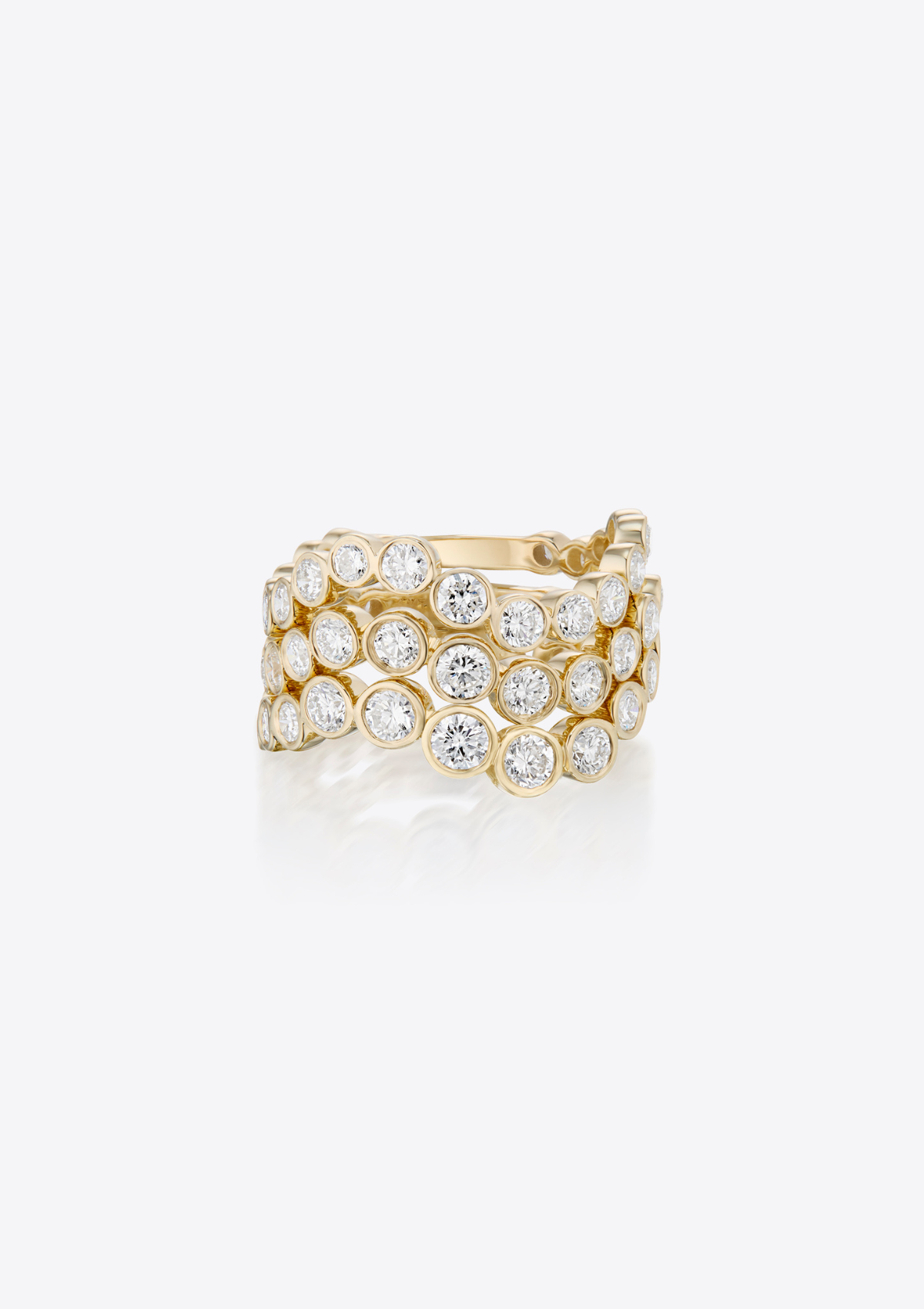 three gold rings with graduating diamonds in a curved design stacked on top of each other on a grey background