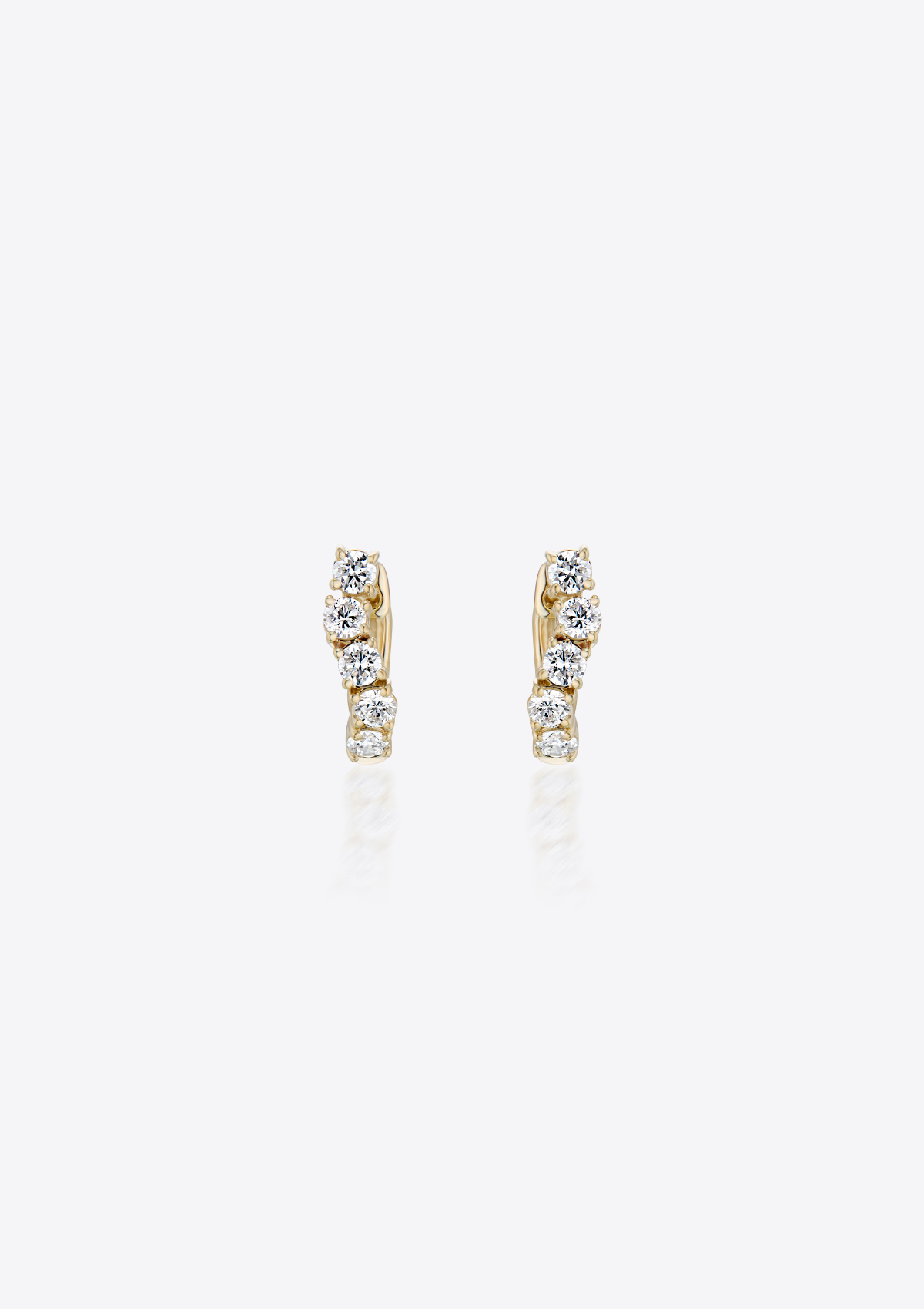 gold diamond huggies in a curved shape against a grey background. front view