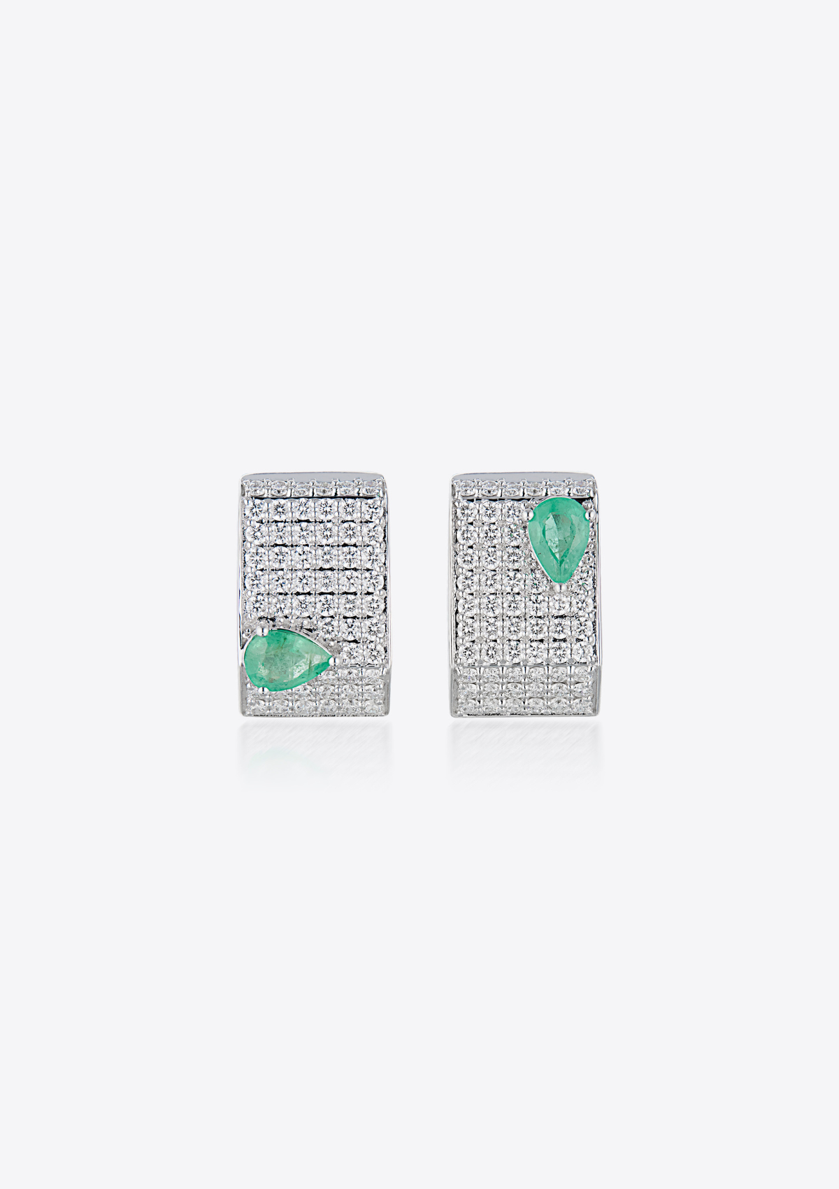 Pair of geometric diamond pave earrings with pear-shaped emeralds on a grey background. front view
