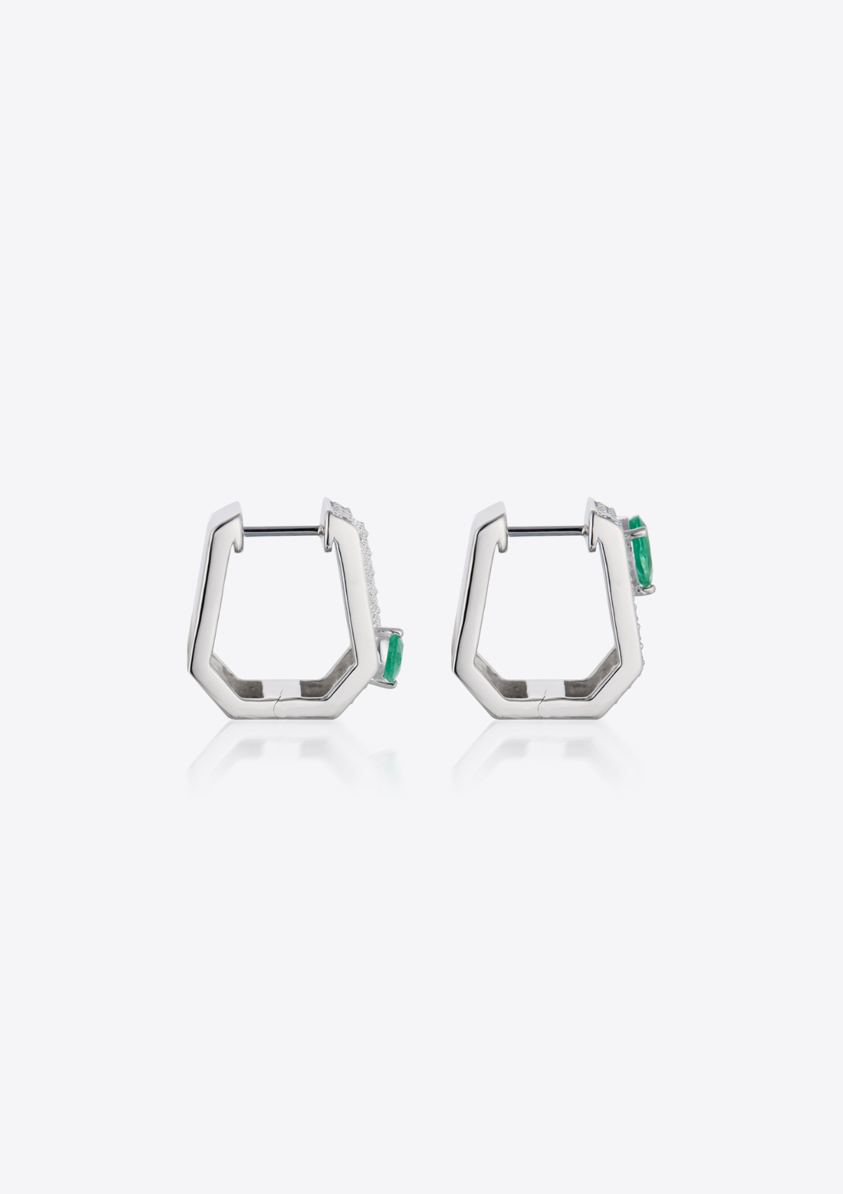 side view of geometric diamond pave earrings with pear-shaped emeralds on a grey background